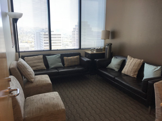 photo glendale office suite 1704, two dark brown sofas with pillows, two tan chairs, three windows
