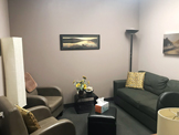 photo sherman oaks office suite 1208, two light green chairs, one dark
 grey sofa, painting on wall