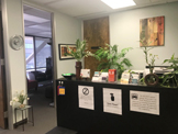 photo sherman oaks suite 1208 reception area/waiting room, dark
 brown desk with greenery, painting on wall