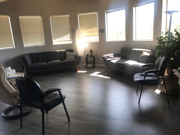 photo Woodland Hills Office Space, panoramic windows, two grey sofas with pillows, two black chairs, white leather chair, greenery